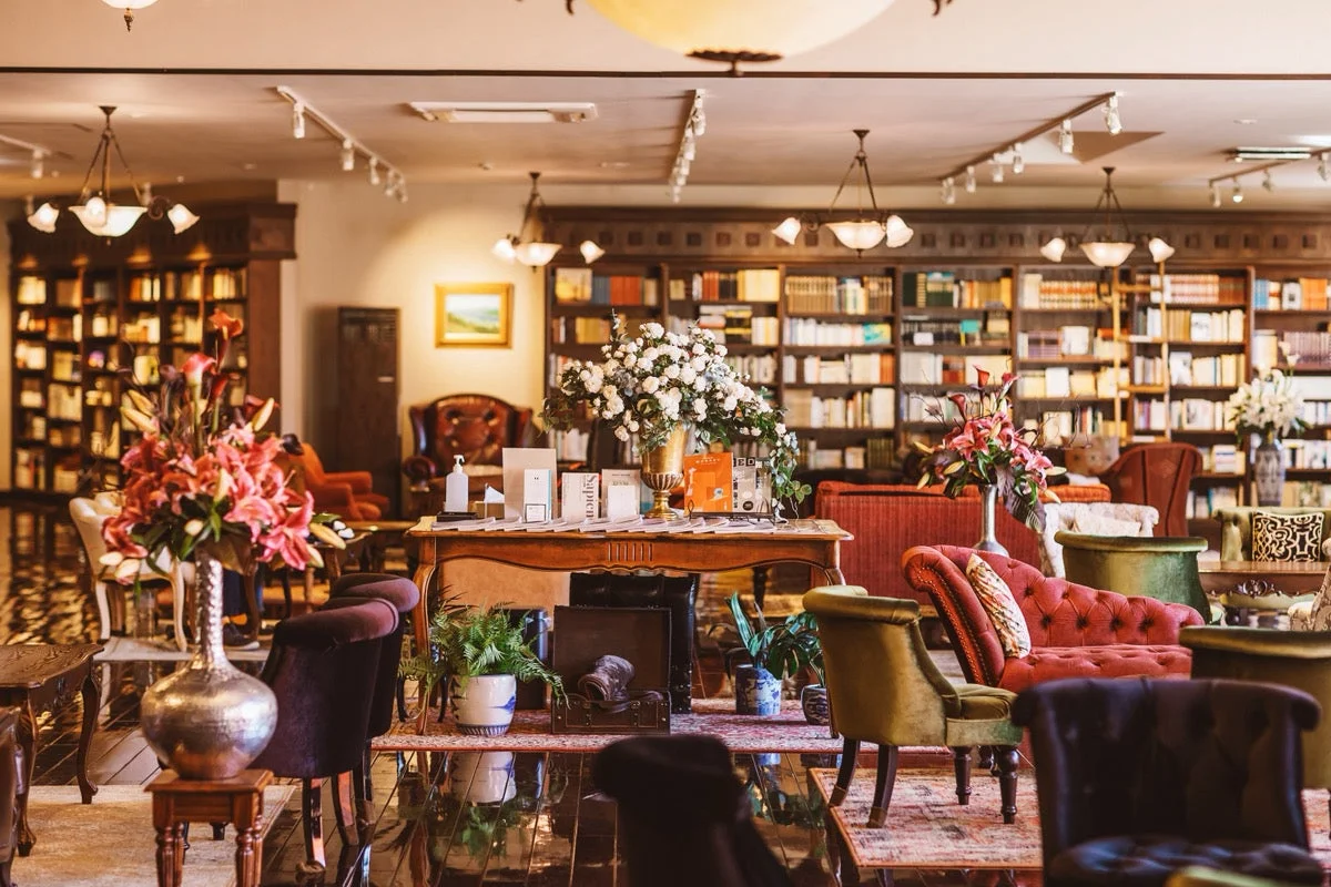 図書館,ラウンジ,書斎,本棚,本,ソファ,アームチェア,花,生け花,クラシック,エレガント,豪華,落ち着いた,室内,インテリア,アンティーク,家具