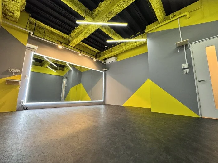 黄色とグレーを基調としたモダンなデザインの空の部屋