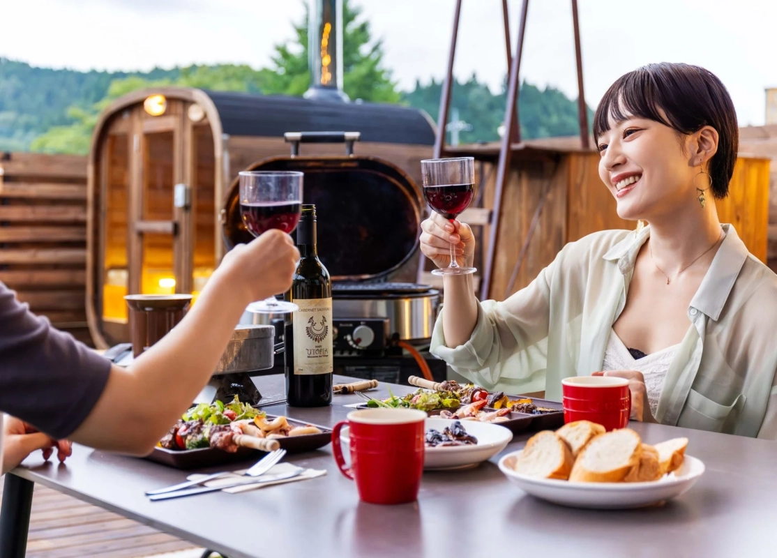 屋外テラスでワインと食事を楽しむ様子