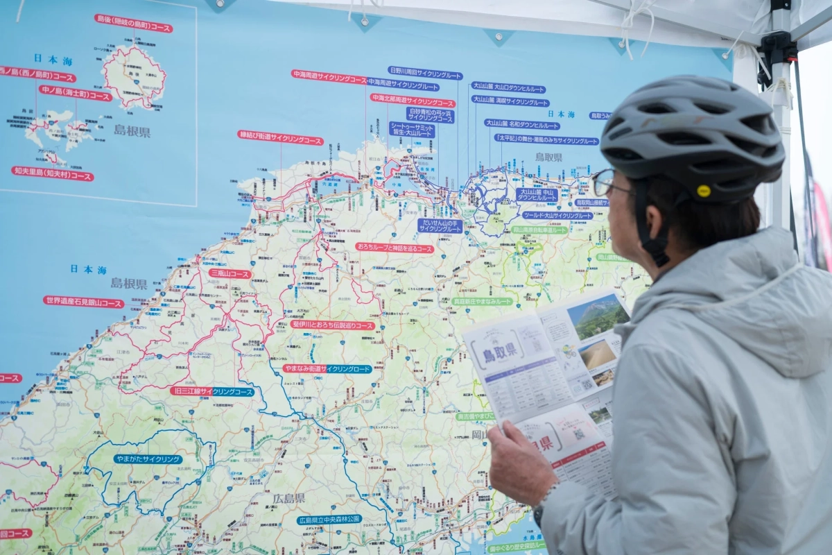 サイクリングヘルメットをかぶった人が地図を見る