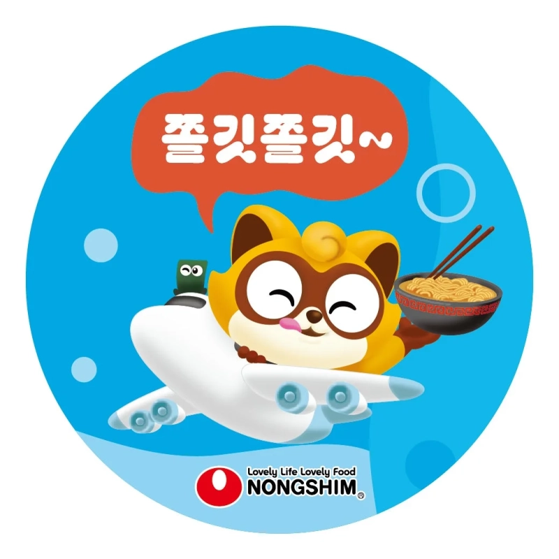 青い背景の円形デザインに、飛行機に乗って空を飛ぶタヌキのようなキャラクターが描かれています。キャラクターは笑顔でラーメンのどんぶりと箸を持っており、吹き出しには「쫄깃쫄깃~」という文字があります。下部には農心のロゴと「Lovely Life Lovely Food」というスローガンが配置されています。