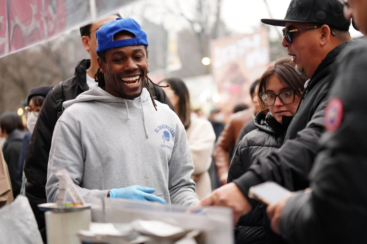 屋外イベントで客と交流する男性