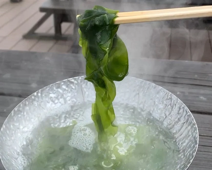 箸で湯通しされているわかめ