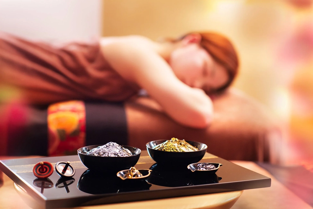 スパでリラックスする女性の姿と、きらめく素材が入ったボウルが写っています