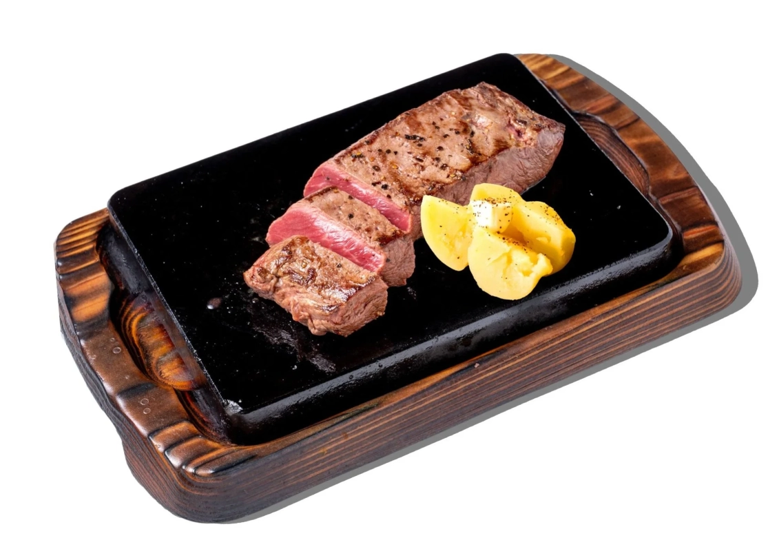 熱々の鉄板ステーキと付け合わせのポテト