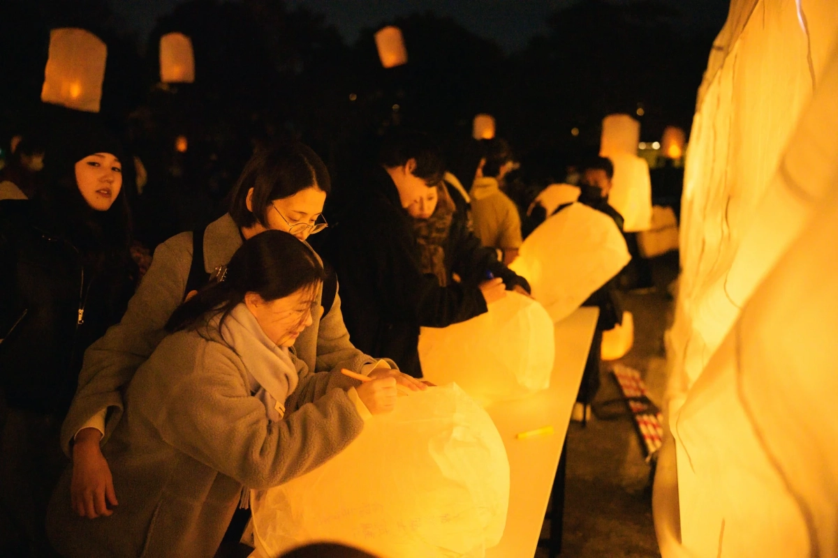 ランタンにメッセージを書く人々