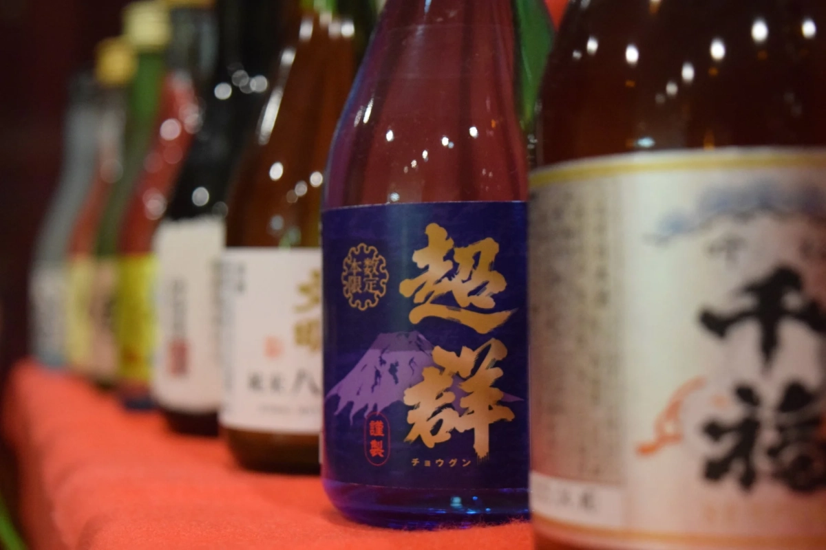 赤い布の上に並べられた日本酒のボトル群