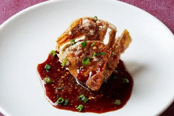 白い皿に盛り付けられたカリッと揚がったソフトシェルクラブのような料理