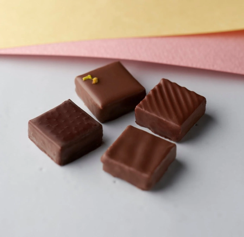 異なるデザインの四角いチョコレートが4つ