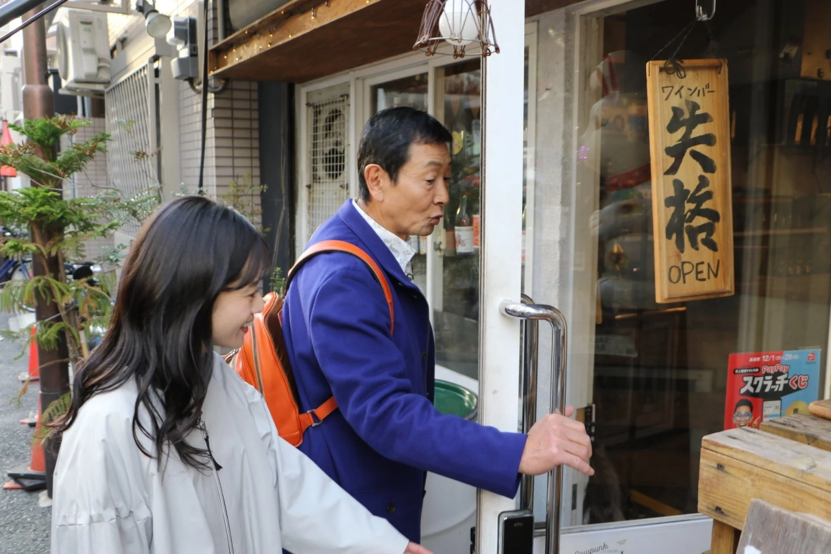 ワインバーのドアを開けようとする男女
