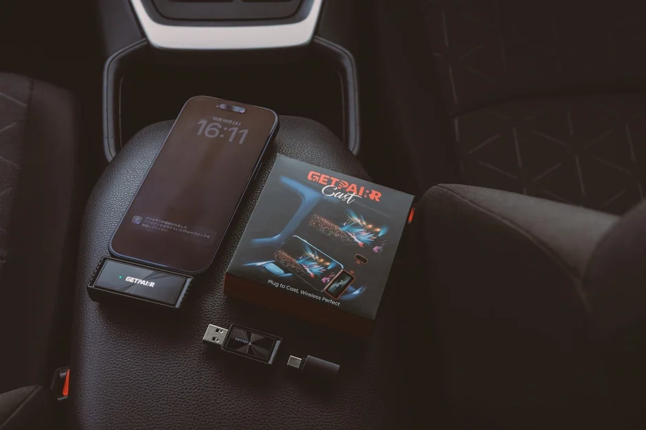車内の座席に置かれたiPhoneと、ワイヤレス接続デバイス