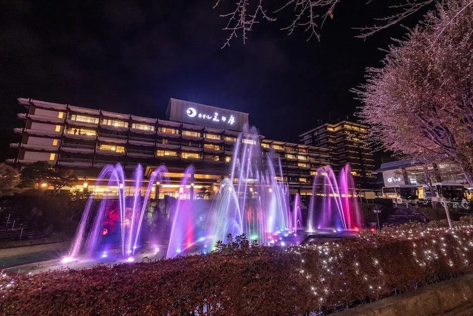 夜間にライトアップされたホテルと、カラフルな光を放つ噴水が美しい夜景です。