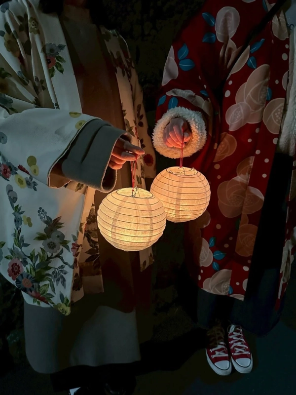 提灯を持って夜の街を歩く人物