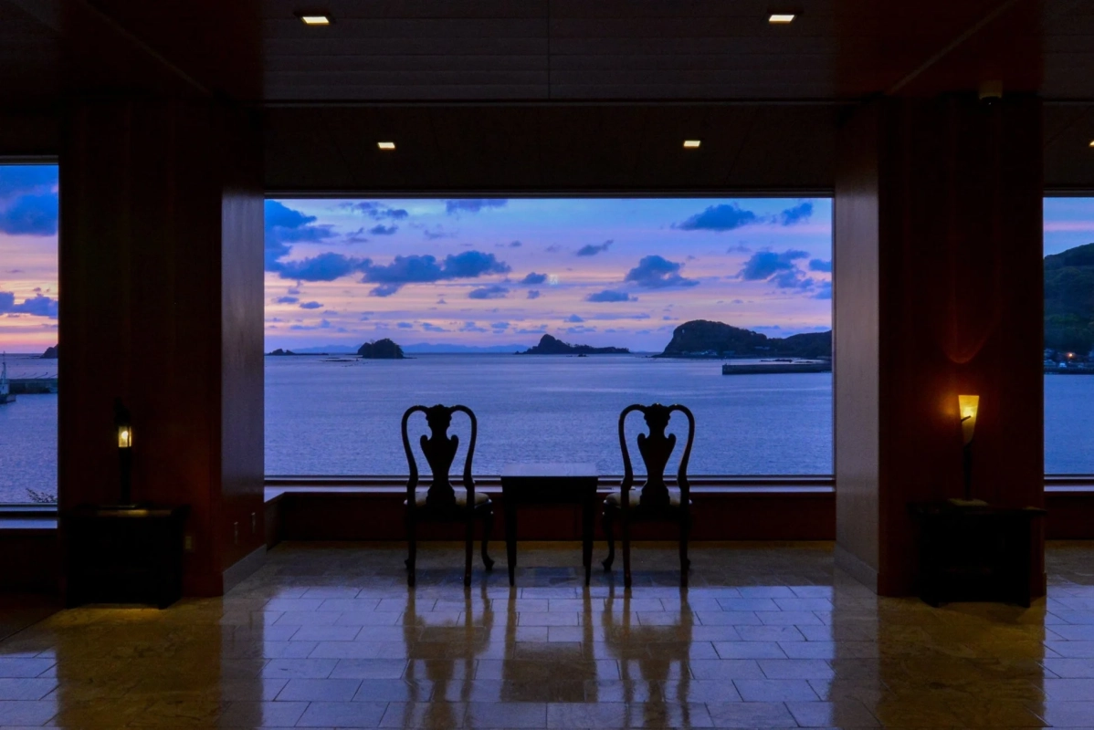 窓辺から夕焼けの海を望む