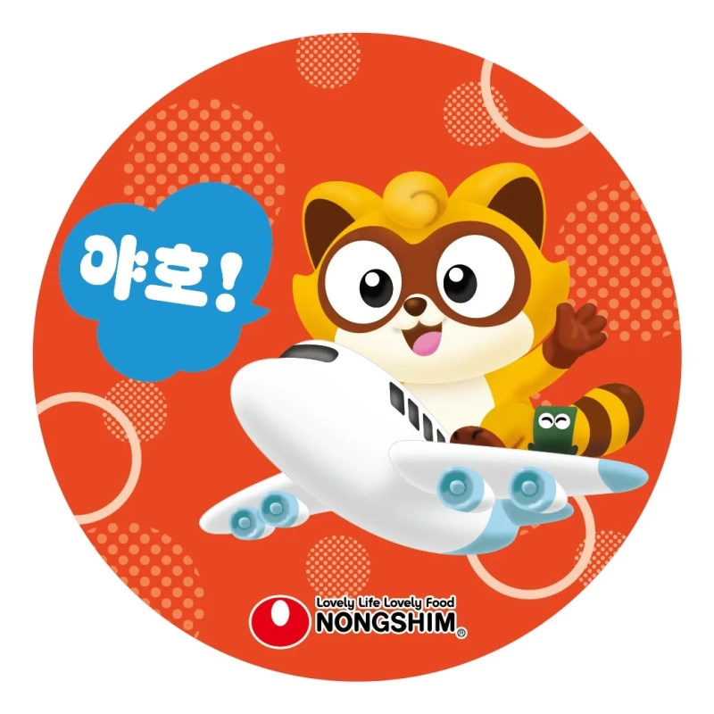 赤い背景に、かわいいアライグマのようなキャラクターが白い飛行機に乗っているイラスト。韓国語の「야호！」という吹き出しと、「NONGSHIM」のロゴが見える。楽しそうな雰囲気のデザインです。