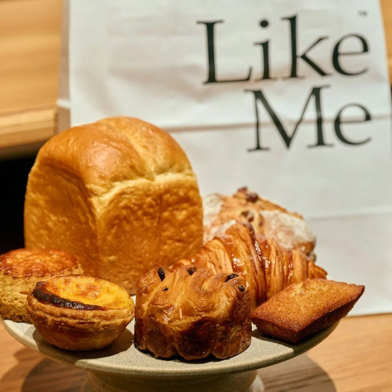 様々な種類の焼き立てパンやスイーツが陶器のスタンドに並べられています