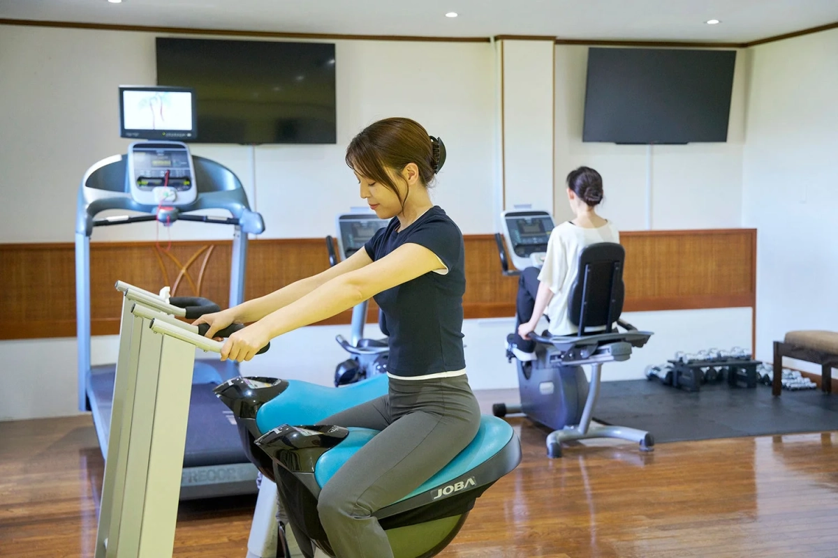 フィットネスジムで運動する二人の女性の様子