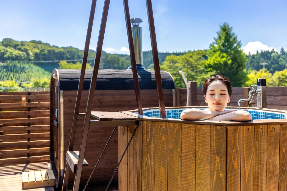 屋外の露天風呂とバレルサウナ