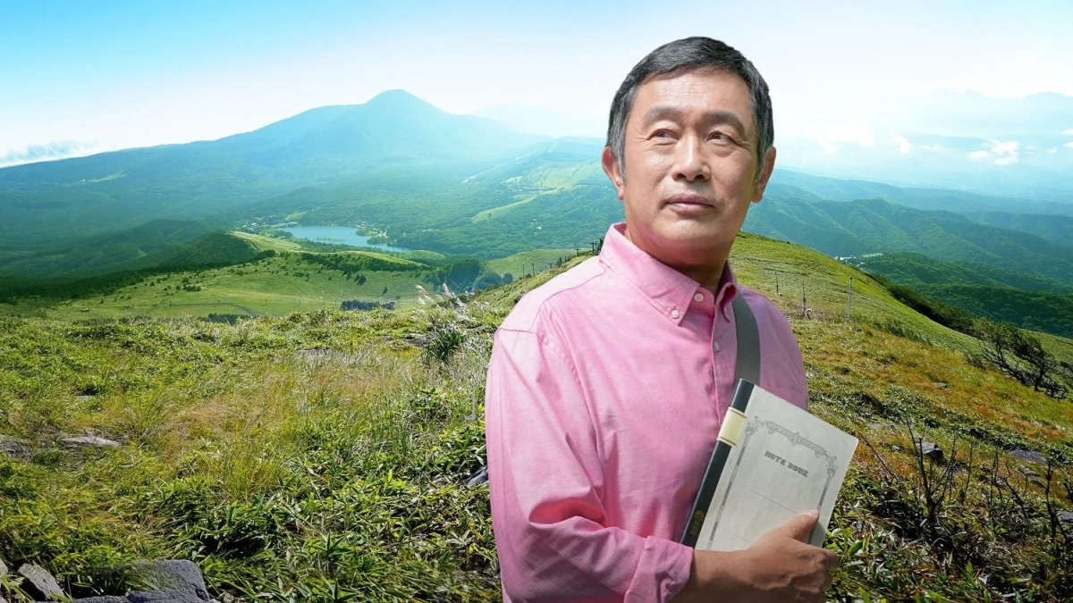 山頂でノートを持つ男性