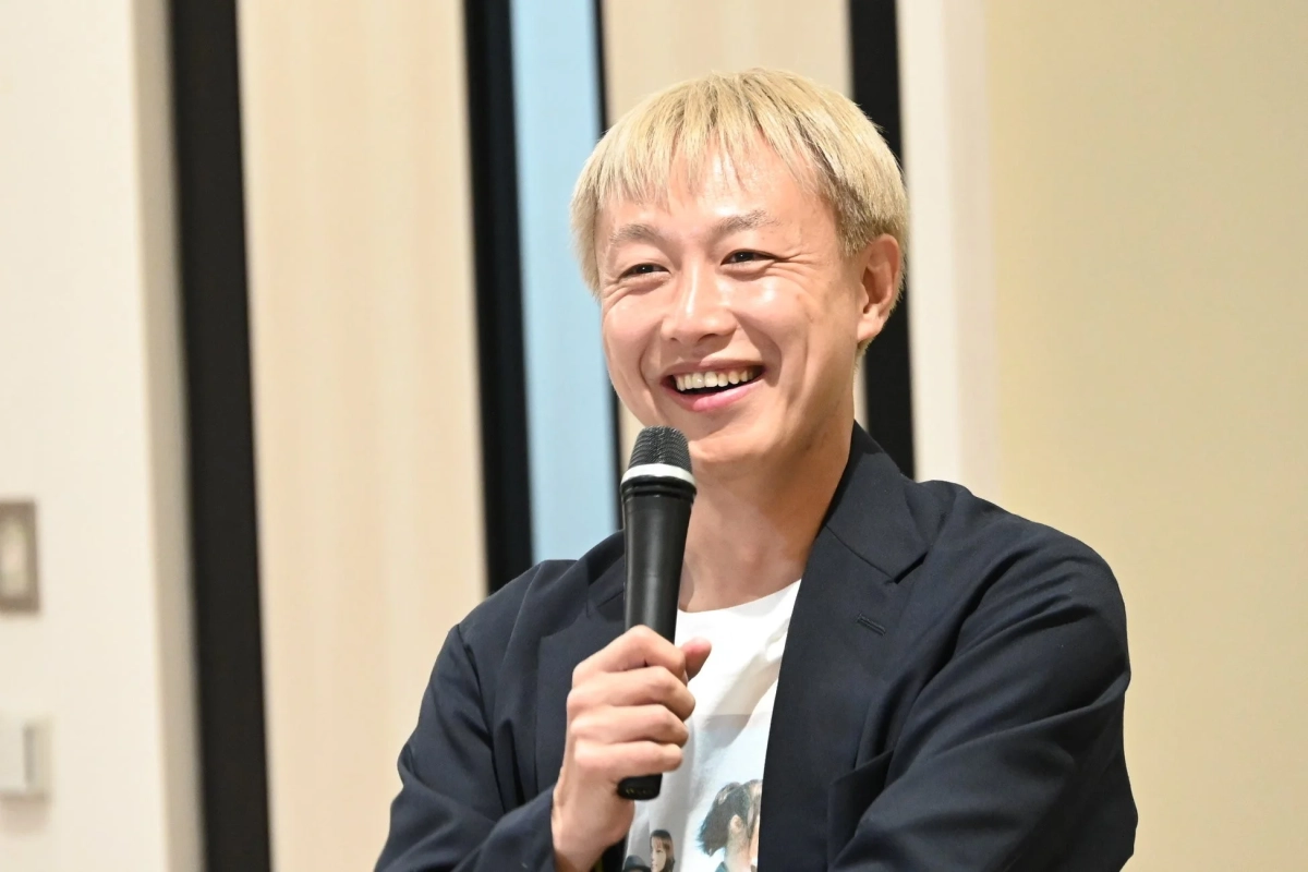 マイクを手に笑顔で話すお見送り芸人しんいちさん