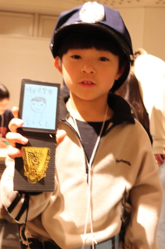 手作りの警察手帳を見せる子ども