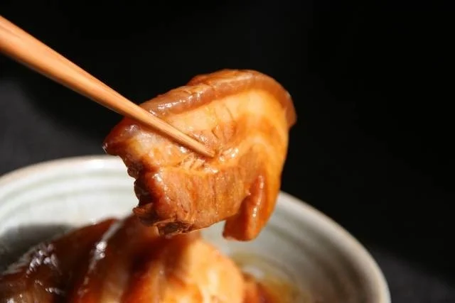 箸で持ち上げられた豚の角煮