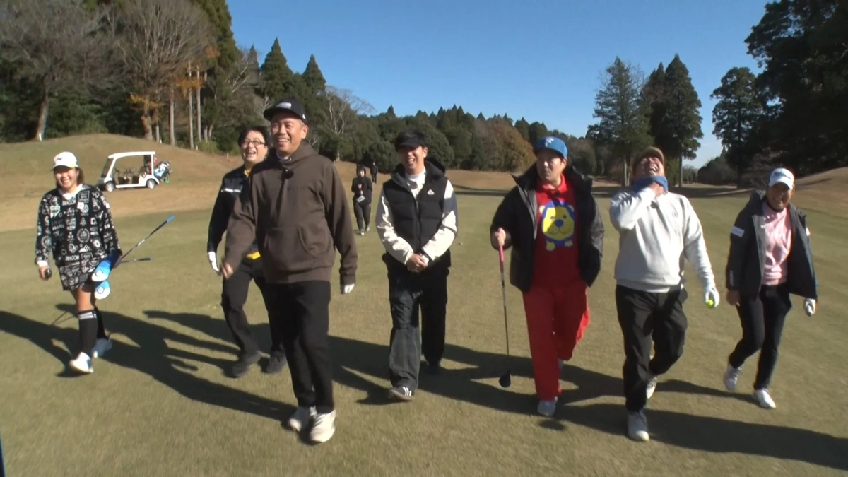 晴れた日のゴルフコースで、男女のグループが楽しそうに歩いている様子。数人が笑顔で談笑しながらゴルフをプレイしており、和やかな雰囲気のレジャー風景が広がっています。