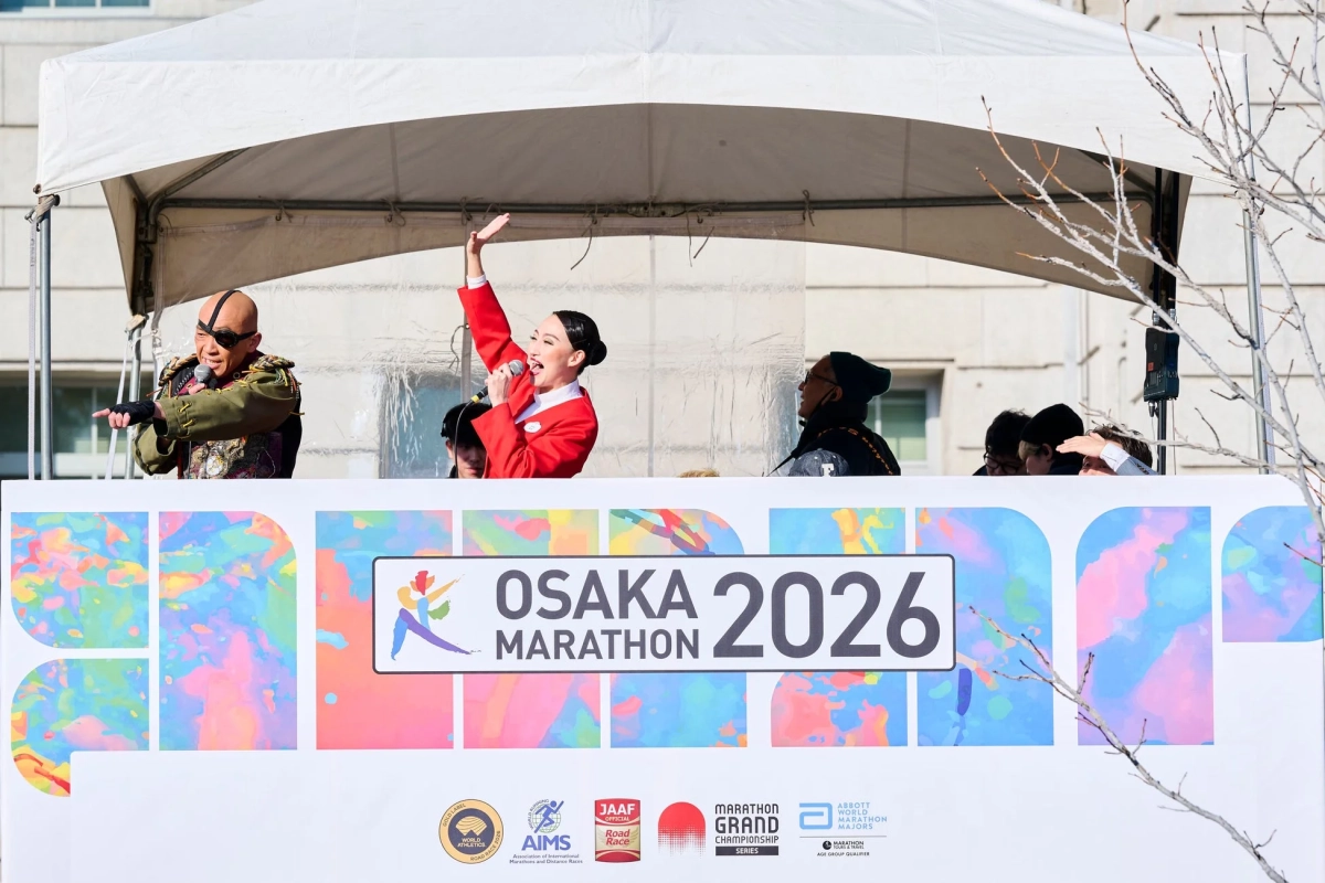 大阪マラソン2026のイベントステージで、MCと歌手がパフォーマンスを行っています。