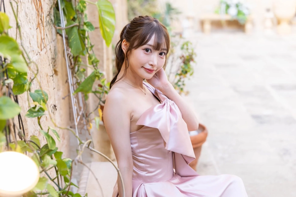 ピンクのオフショルダードレスを着て微笑む女性