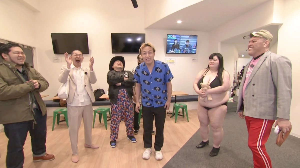 スタジオで笑う芸人たちと水着の女性