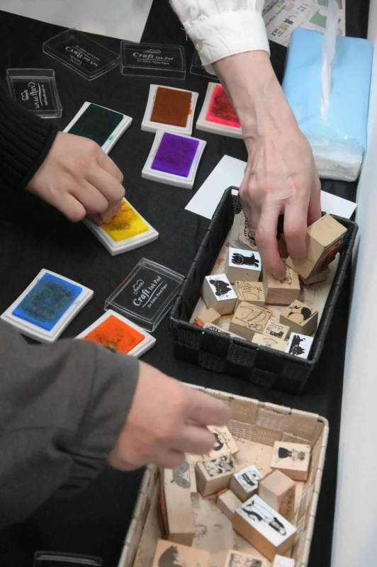 複数の人がテーブルを囲んでスタンプアートを楽しんでいる様子