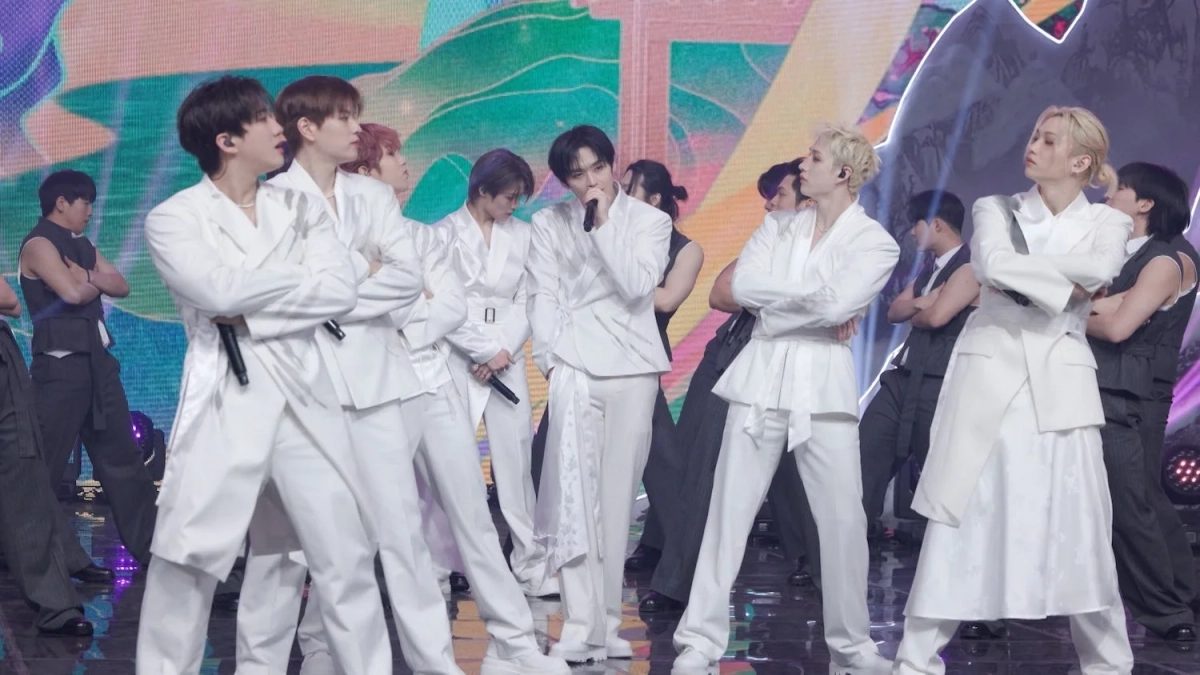 白い衣装をまとった男性アイドルグループがステージでパフォーマンスしている様子です。