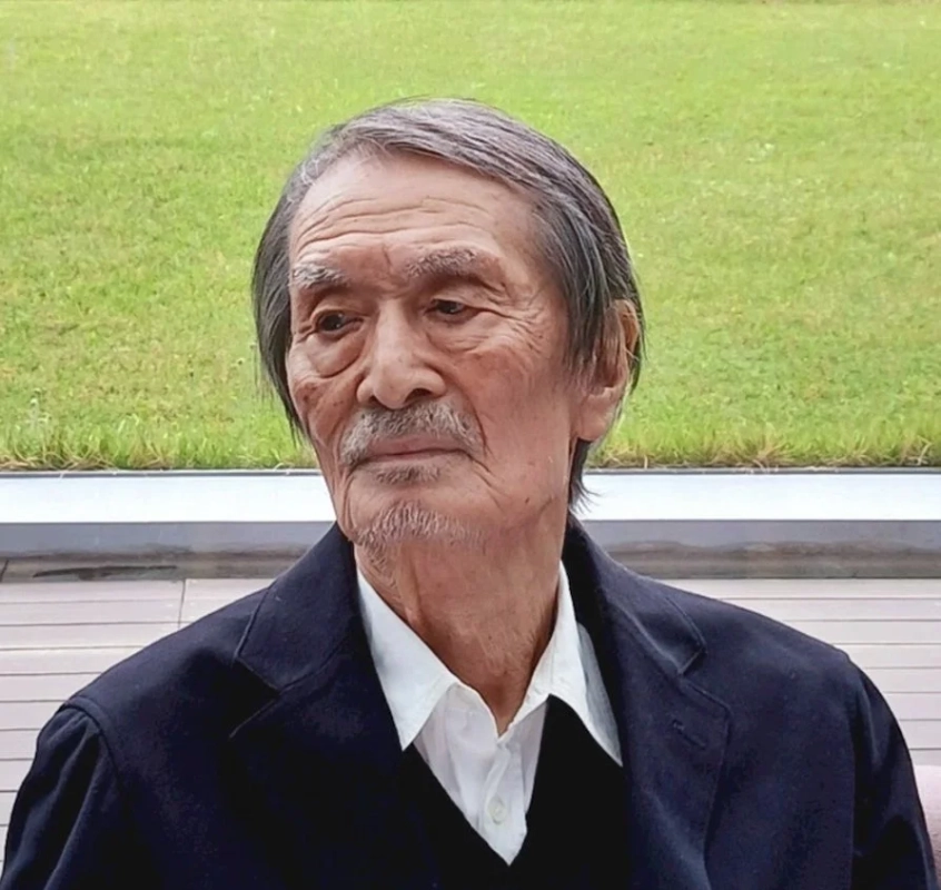 白髪と口ひげを蓄えた高齢の東洋人男性