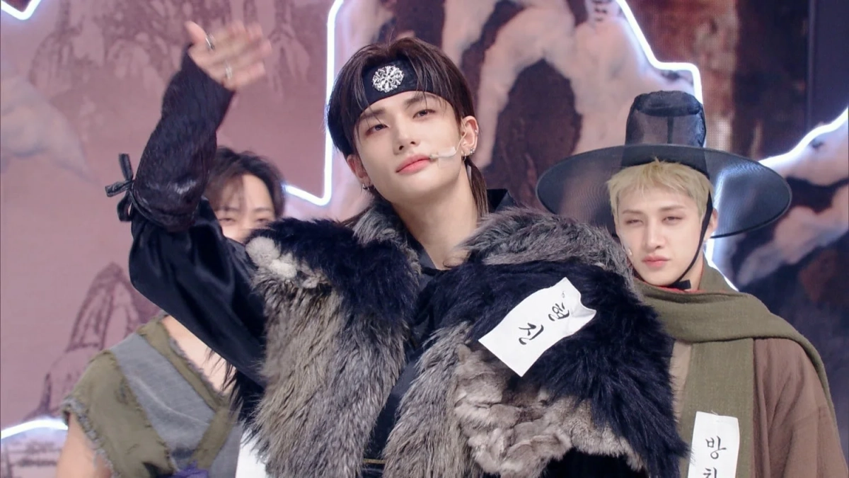 K-POPアイドルグループStray Kidsのメンバーが、伝統的な韓国の衣装を現代風にアレンジしたコスチュームでステージに立つ姿。