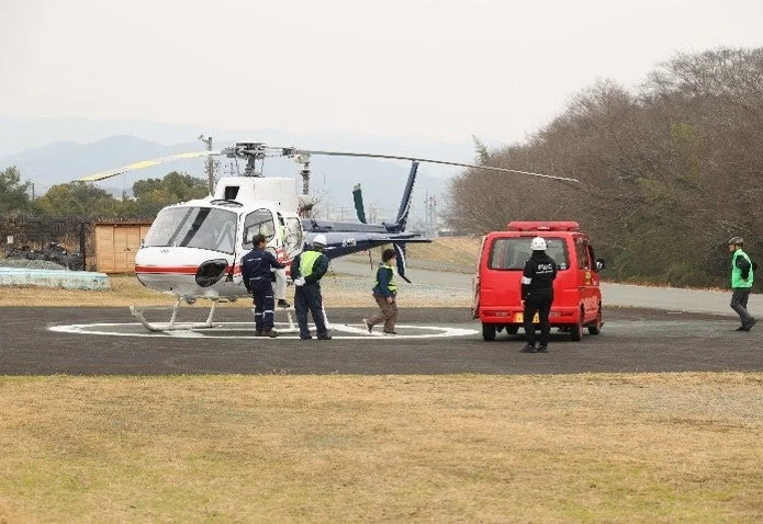 ヘリポートに着陸したヘリコプターと緊急車両
