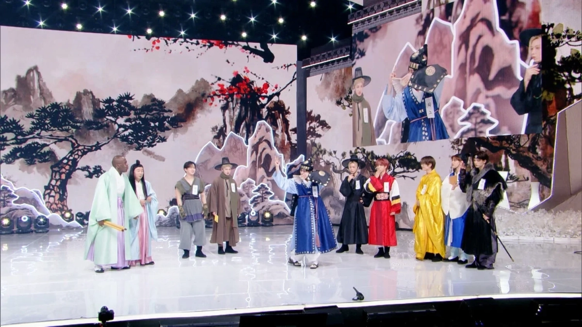 華やかな舞台で、複数の人々が色とりどりの伝統的な韓服を着用してパフォーマンスを行っています。