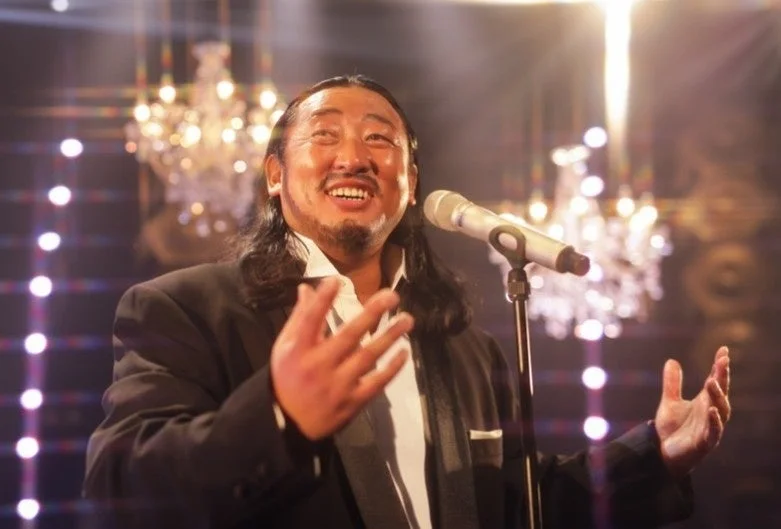 スーツ姿で歌唱する秋山竜次さん