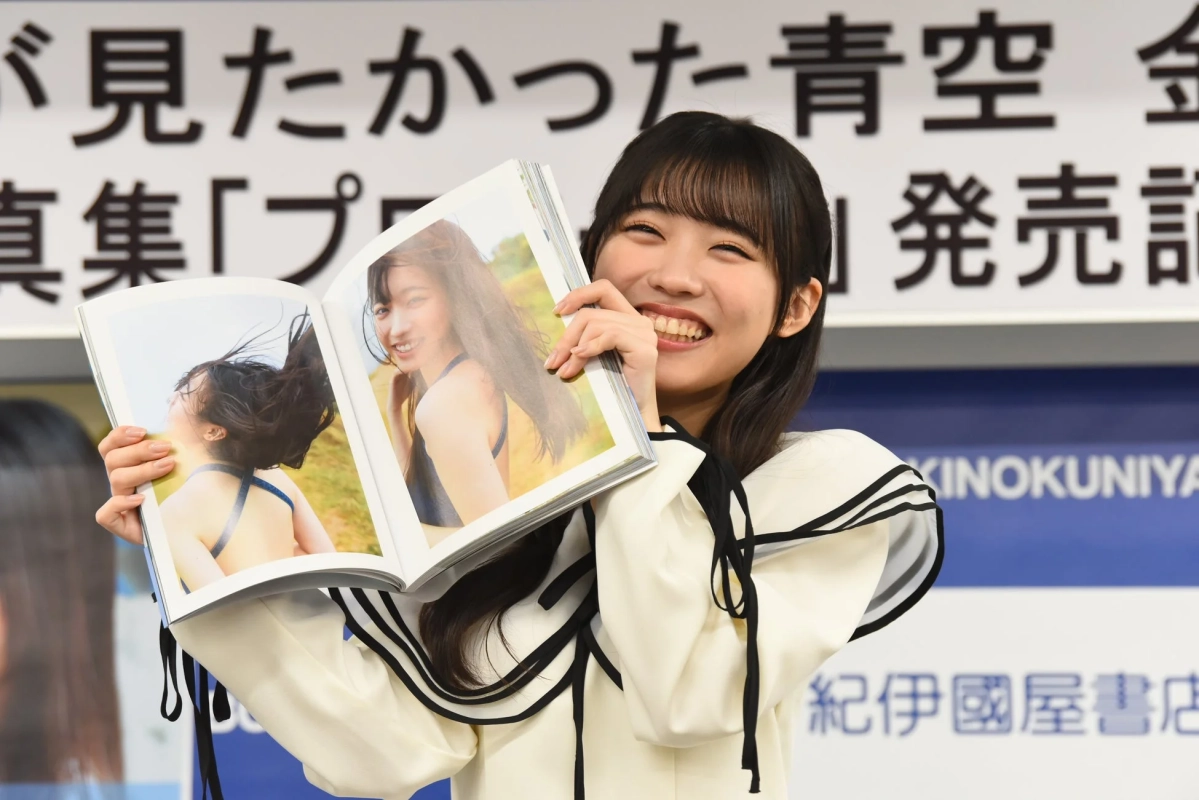 金澤亜美さんが写真集を持つ笑顔、水着写真も見える