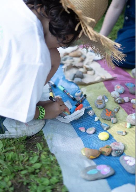 屋外で石に絵を描く子供