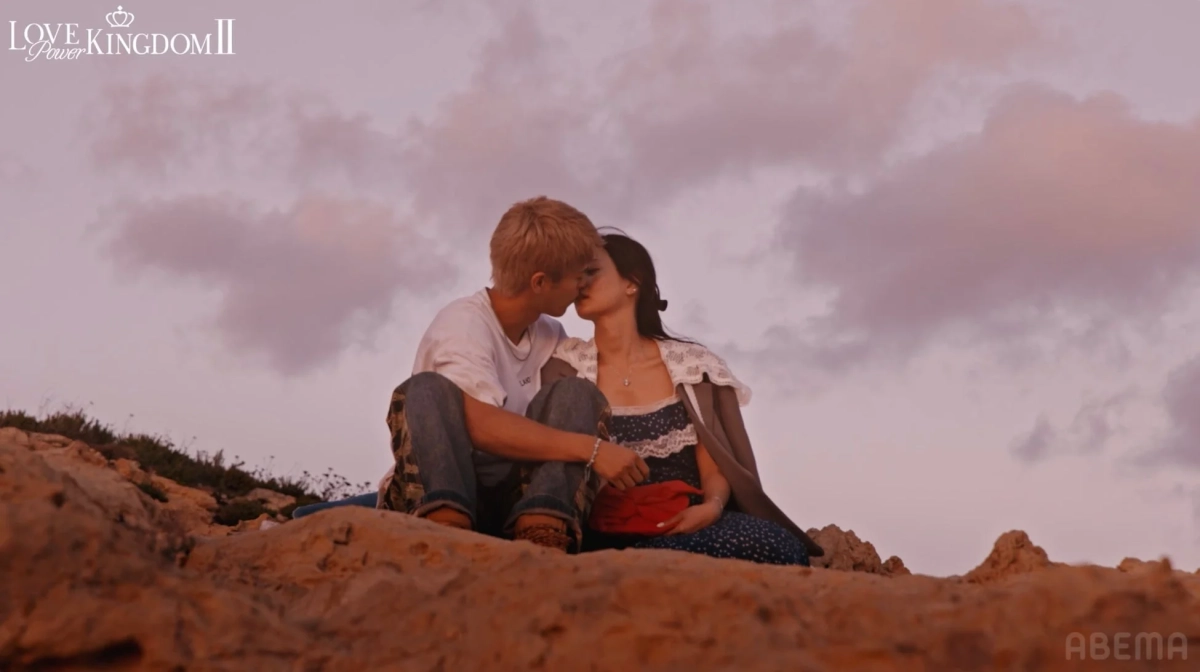 夕暮れの丘でキスをするカップル