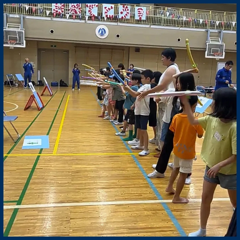 体育館でバルーンロケットを体験する子供たち
