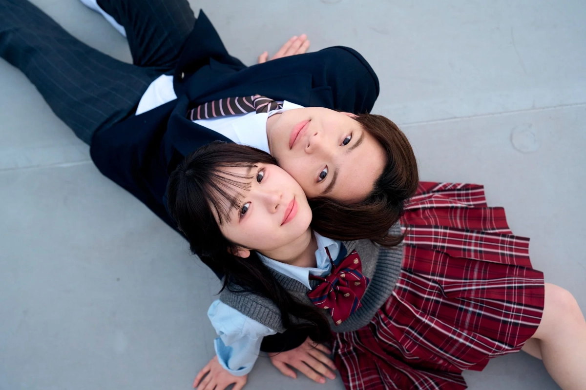 制服姿で寄り添い地面に寝転がる男女の高校生