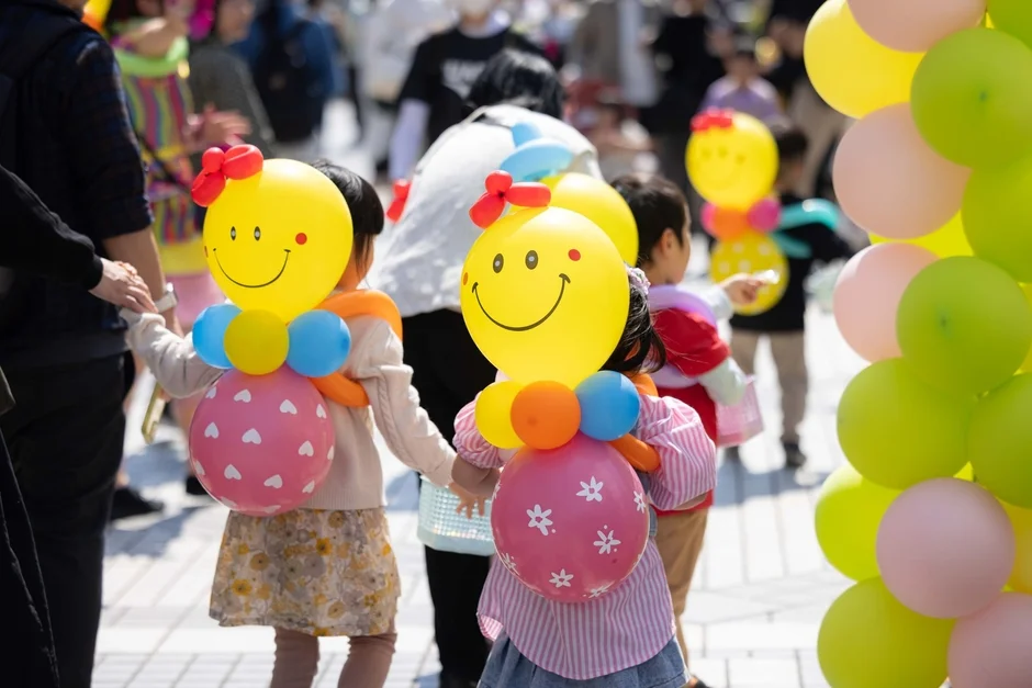 笑顔のバルーンアートを身につけた子供たち
