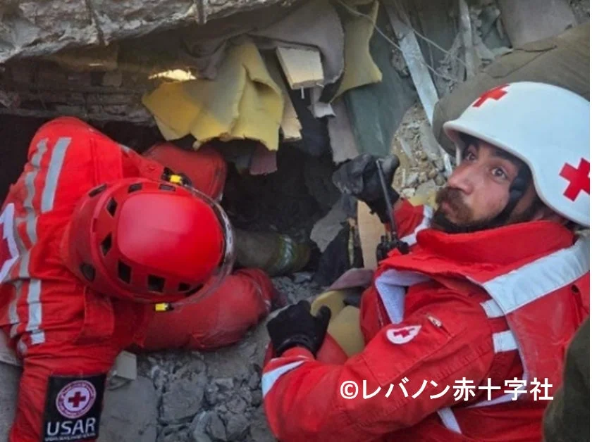 倒壊した建物の瓦礫の中で、レバノン赤十字社の救助隊員が捜索活動を行っています