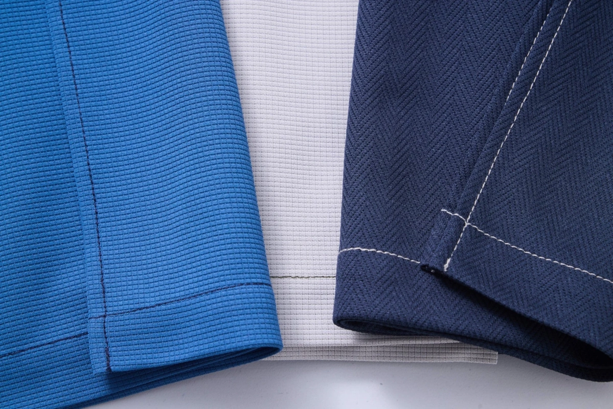 青、濃紺、淡いグレーの3種類の生地のテクスチャと縫製部分をクローズアップした画像です。それぞれの異なる織り方やステッチのディテールがはっきりと見て取れます。