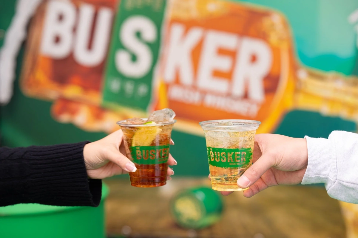 THE BUSKERのロゴ入りカップで乾杯する様子