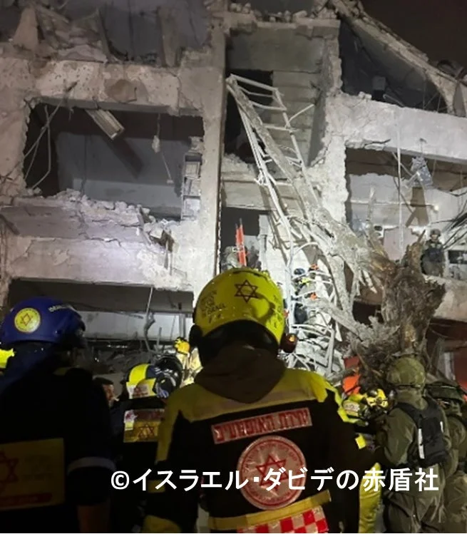 夜間、崩壊した建物の残骸の中で、イスラエルの救急隊員が救助活動を行っている様子