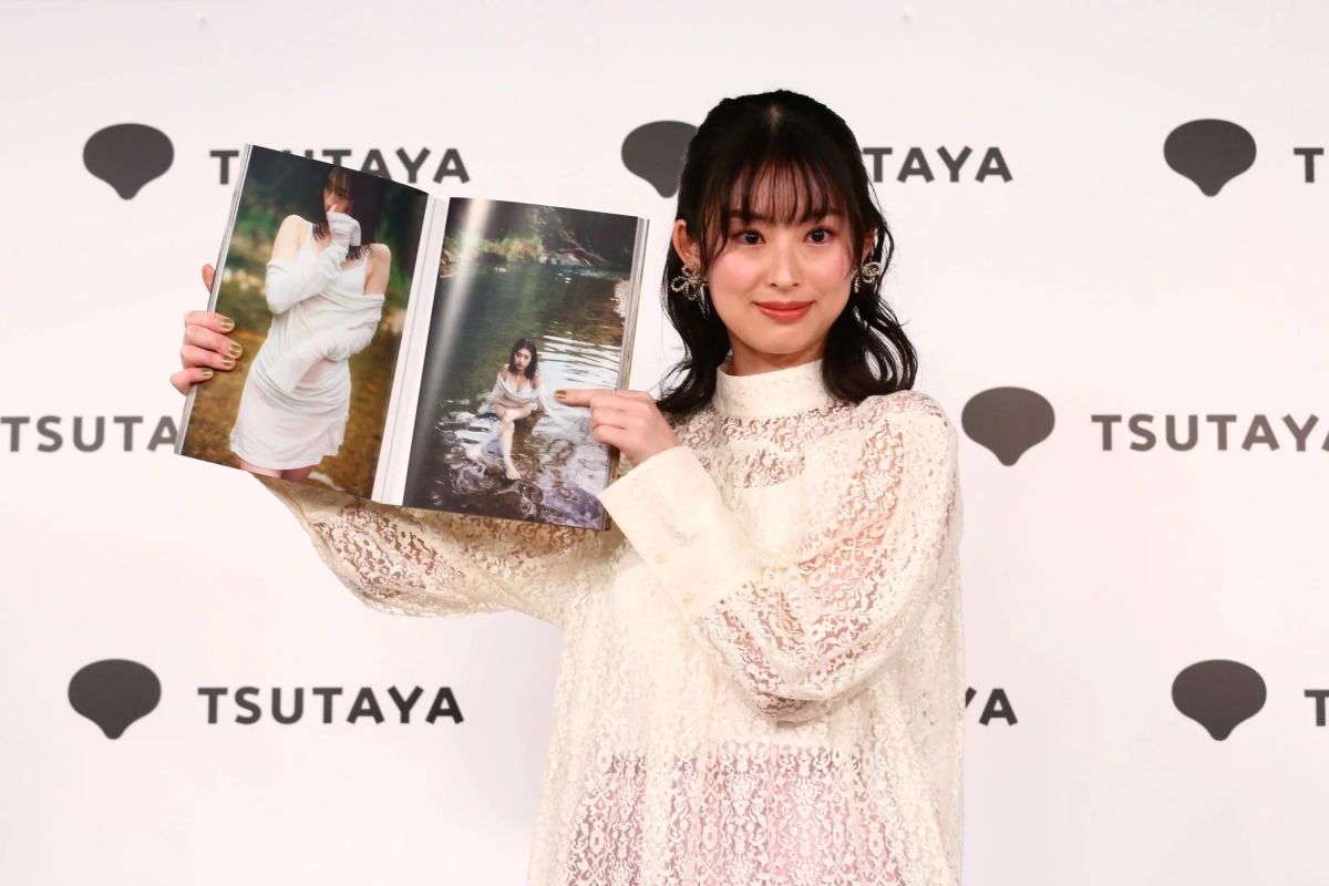 写真集のページを指差す井本彩花さん