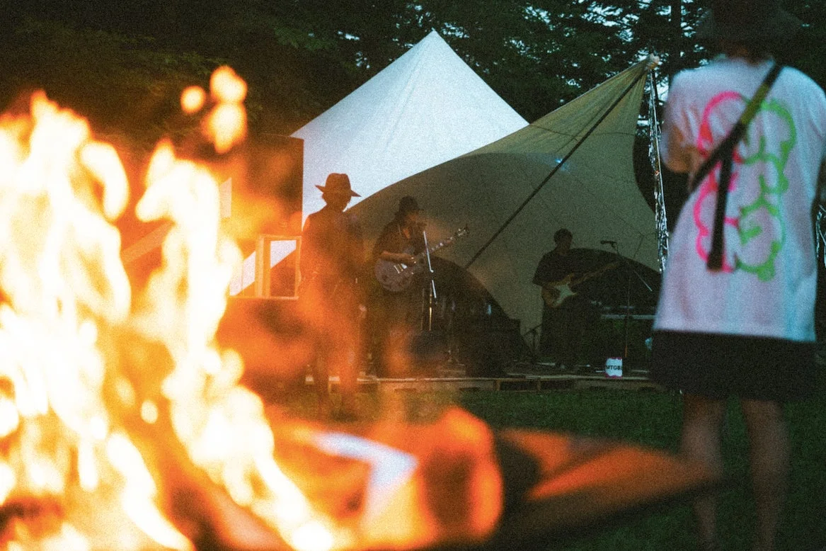 夜の野外フェスで焚き火とバンド