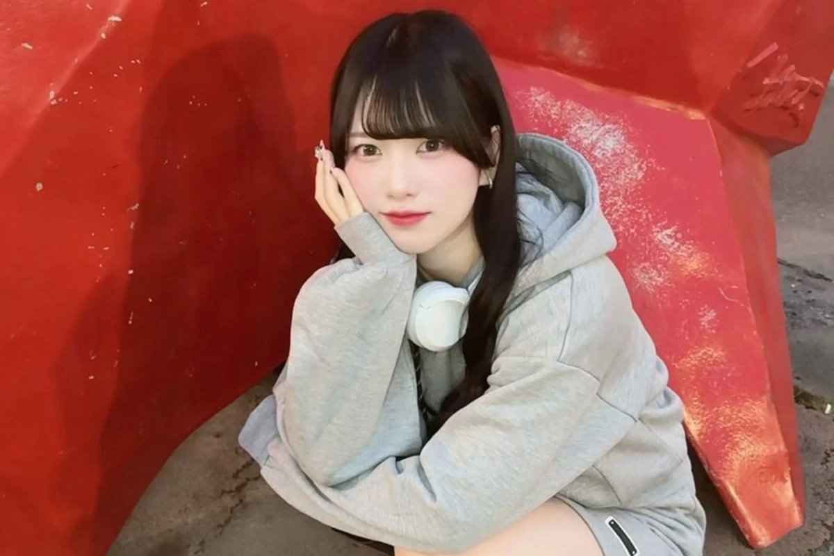 若い女性が頬に手を当ててカメラを見つめているポートレート写真